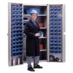 Combination bin security cabinet with a person standing in front of it and blue bins with materials inside on a white background.