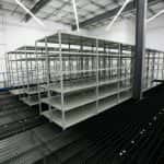 Industrial open shelving that is empty in a warehouse setting.