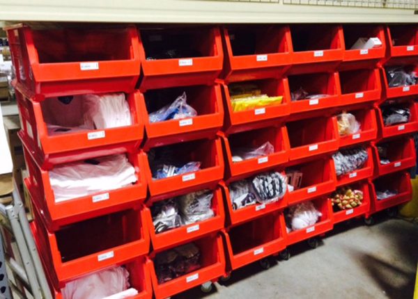 Red extra large plastic bins stacked on top of each other storing materials in a warehouse setting.