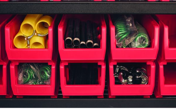 Red extra large plastic bins stacked on top of each other storing materials in a warehouse setting.